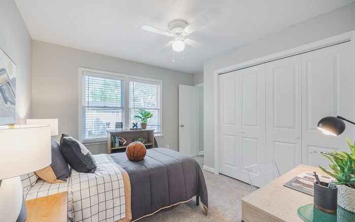 Brightly lit bedroom featuring cozy decor, modern furniture, and a fresh plant, perfect for relaxation and creativity.