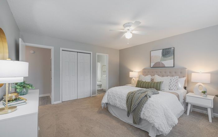 Inviting bedroom with a plush bed adorned with decorative pillows, modern lighting, and contemporary art. Neutral tones enhance the calm ambiance.
