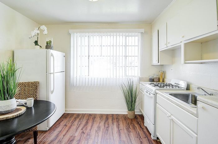 Charming kitchen with white cabinets, a modern gas stove, and bright natural lighting creating an inviting atmosphere.