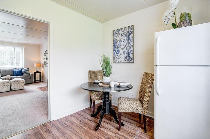 Bright and inviting dining area with a cozy round table, vibrant decor, and a glimpse into the elegant living room, perfect for comfortable living.