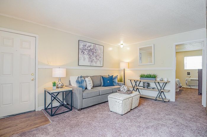 Inviting living room with contemporary decor, featuring a cozy grey sofa, stylish side tables, and elegant lighting for a warm ambiance.