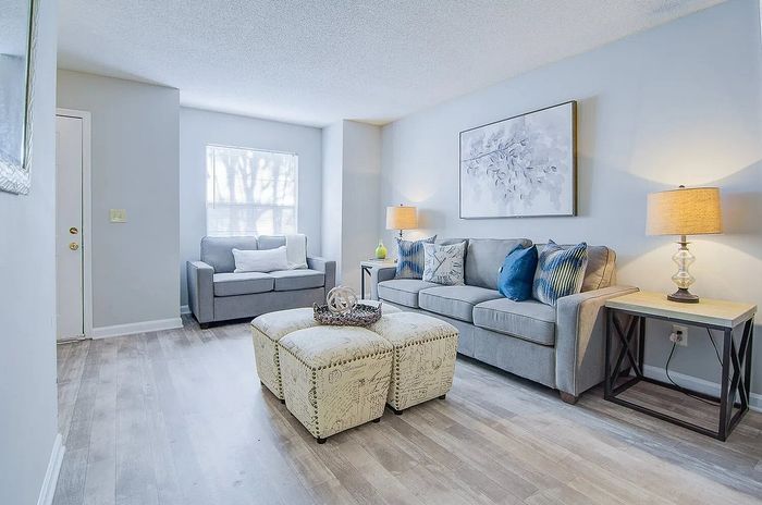 Charming living room with modern gray sofas, soft lighting, and elegant decor, creating a cozy, inviting ambiance.