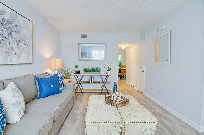 Inviting living room with modern gray sofa and vibrant blue accents, featuring a stylish coffee table and elegant wall art.