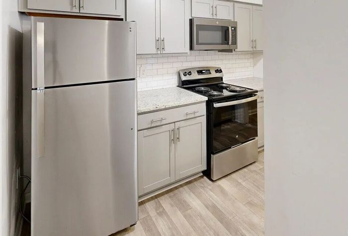 Modern kitchen with sleek stainless steel appliances, elegant white cabinetry, and chic subway tile backsplash.