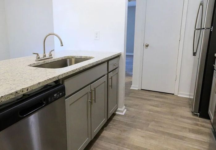 Elegant kitchen with sleek granite countertops, modern stainless steel appliances, and stylish cabinetry on beautiful wood flooring.