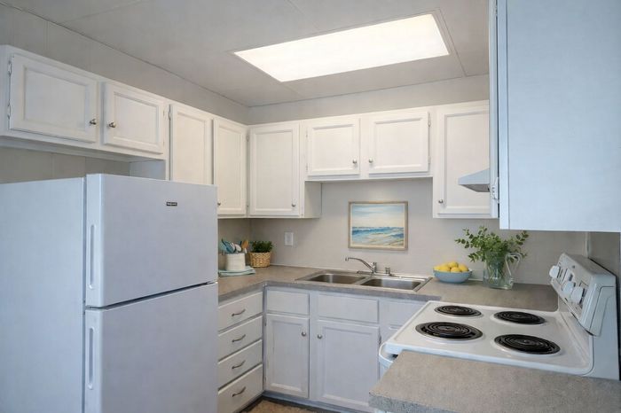 Charming kitchen with white cabinetry, modern appliances, and a cozy countertop space.