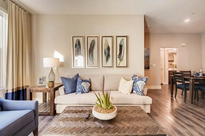 Inviting living room with elegant decor, comfortable seating, and stylish artwork, seamlessly connected to a modern dining area.