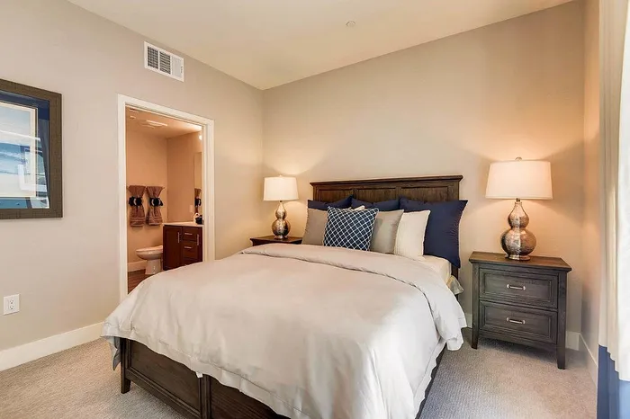 Elegant bedroom with cozy bedding, warm lighting, and stylish decor enhances relaxation and comfort.
