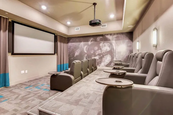 Luxurious private home theater with plush reclining seats, a large screen, and modern lighting for an immersive cinema experience.