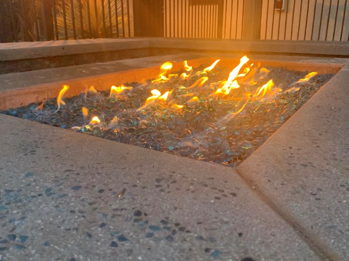 Inviting outdoor gas fire pit with vibrant flames and decorative glass accents, perfect for cozy evenings.