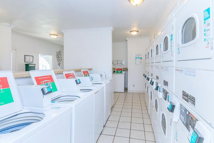 Bright and spacious laundry room with modern washing machines and dryers, ideal for convenient apartment living.