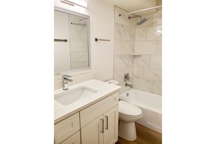 Elegant bathroom with modern fixtures, sleek vanity, and luxurious marble-tiled shower.