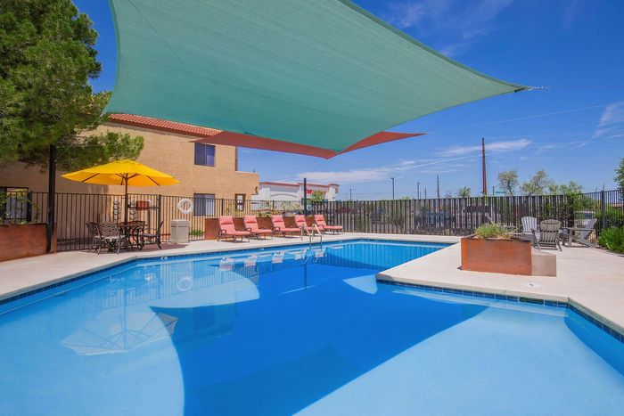 Inviting outdoor pool area with vibrant loungers and shaded seating, perfect for relaxation and enjoyment.