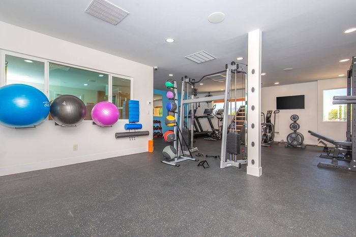 Modern fitness center with state-of-the-art equipment, colorful exercise balls, and spacious workout areas.