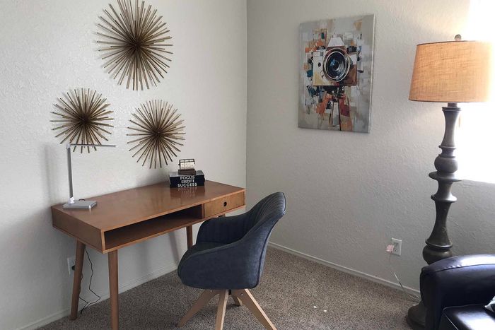 Stylish home office with a sleek wooden desk, modern lamp, and artistic wall decor, creating a perfect workspace atmosphere.