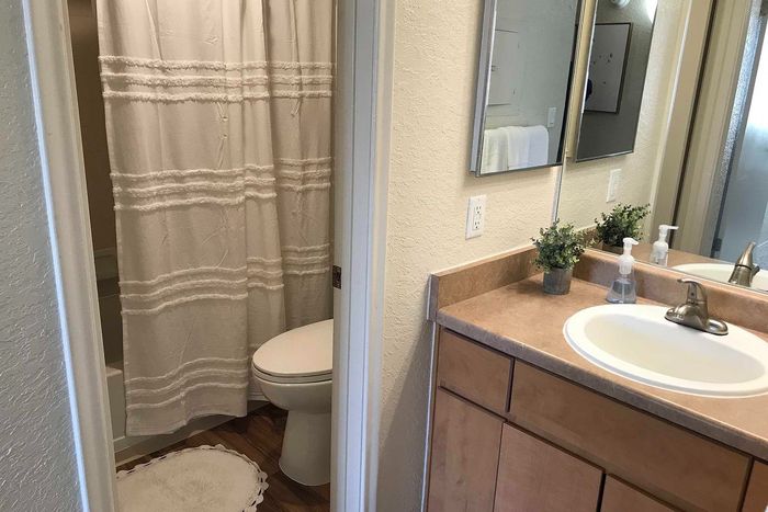 Inviting bathroom with elegant countertop, modern fixtures, and cozy patterned shower curtain.