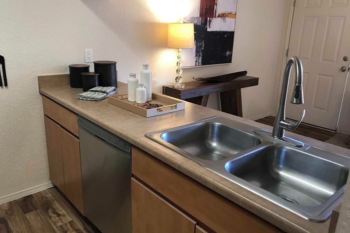 Chic kitchen corner featuring a modern double sink, elegant counter decor, and cozy lighting.