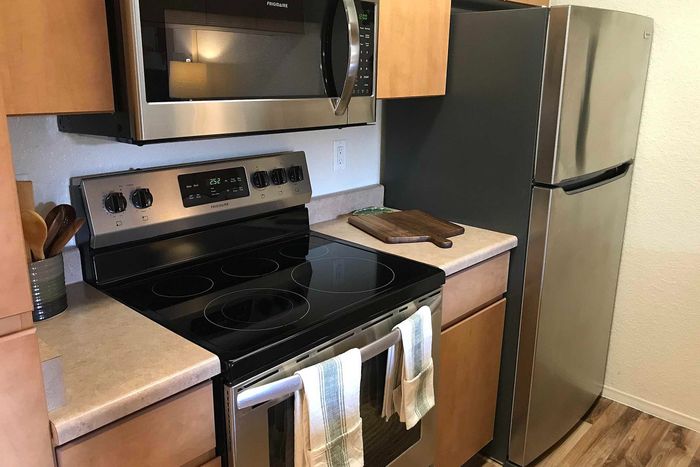 Modern kitchen with stainless steel appliances, sleek countertops, and wooden cabinetry offering a stylish cooking space.