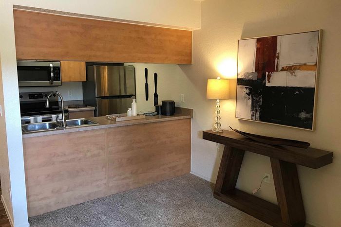 Modern kitchen with stainless steel appliances, warm wood cabinetry, and elegant decor. Open layout enhances the cozy ambiance.