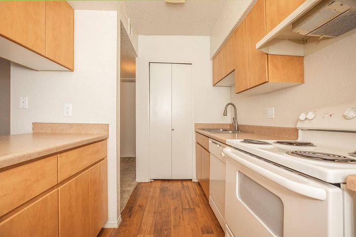Modern kitchen with sleek cabinetry, laminate countertops, and a compact yet efficient layout featuring a stove and sink.