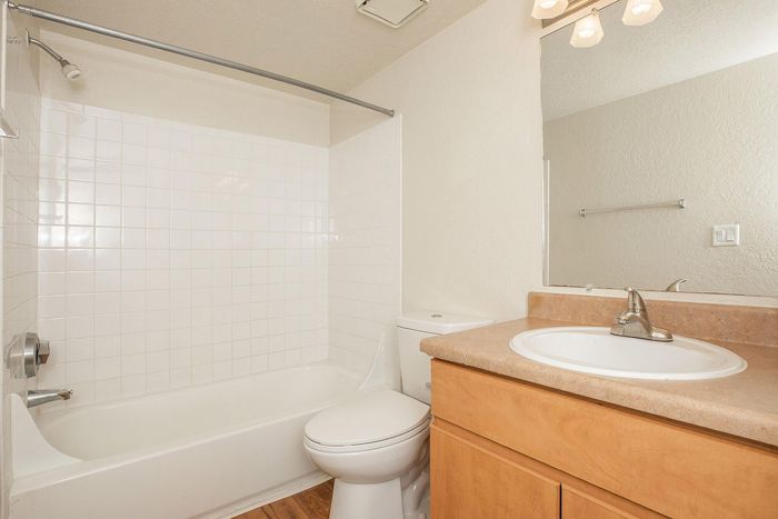 Bright and inviting bathroom with a sleek white bathtub, modern sink, and elegant wood cabinetry.