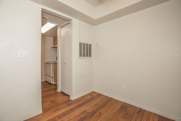 Bright kitchen entrance with modern wood flooring and subtle beige walls, perfect for a cozy living space.