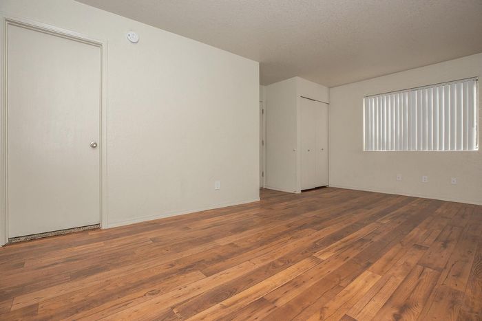 Spacious room with elegant wooden flooring, ample natural light, and modern finishes, perfect for stylish living.