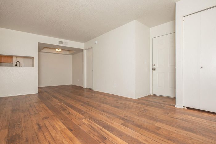 Bright and inviting living space with elegant hardwood floors and a modern open layout, perfectly designed for comfort and style.