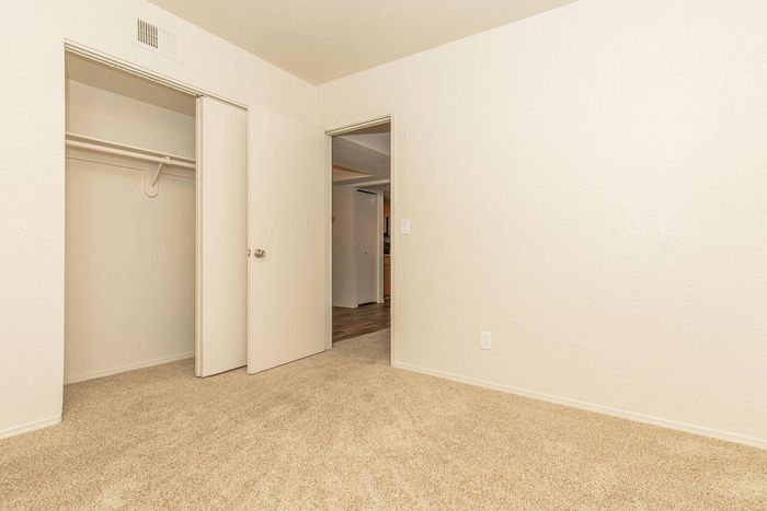 Bright, spacious bedroom with plush carpeting and ample closet space, offering a welcoming blank canvas for your dream home.