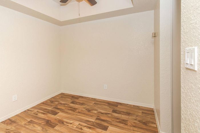 Cozy room with elegant hardwood flooring and modern ceiling fan, perfect for a peaceful retreat.