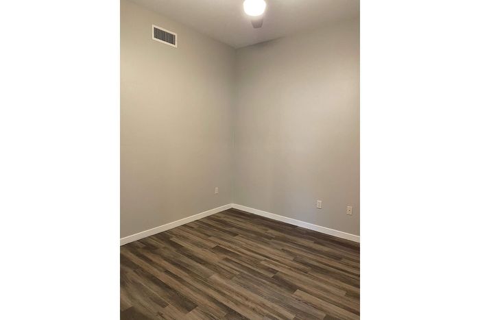 Inviting room with elegant wood flooring and soft neutral walls, perfect for personalized decor and style.