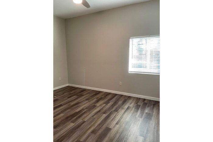 Bright, spacious room with elegant wood flooring and ample natural light from a large window, perfect for creative interior ideas.