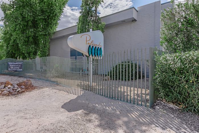 Charming entrance to Palisade Flats with lush greenery and modern signage, offering a welcoming atmosphere for new residents.