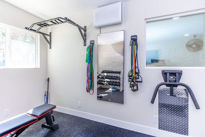 Contemporary home gym with sleek equipment, vibrant resistance bands, and ample natural light for an energizing workout experience.