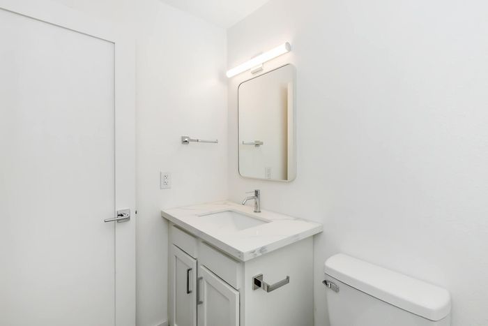 Elegant bathroom featuring a modern vanity with a sleek marble countertop and stylish chrome fixtures.