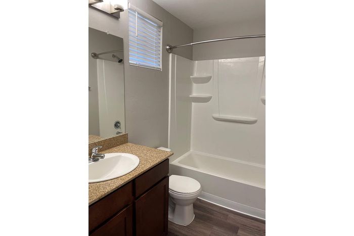 Modern bathroom with elegant granite countertop, sleek vanity, and pristine bathtub for a relaxing experience.