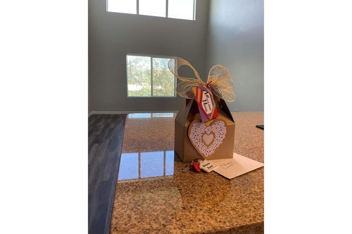 Inviting new home with elegant granite countertop and a warm welcome gift, featuring a large, sunlit window in the background.