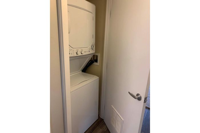 Compact in-unit laundry area featuring a convenient stackable washer and dryer, perfect for modern living.