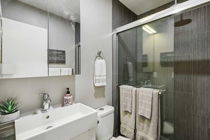 Modern bathroom featuring a sleek vanity, stylish tile accents, and a glass-enclosed shower for a luxurious touch.