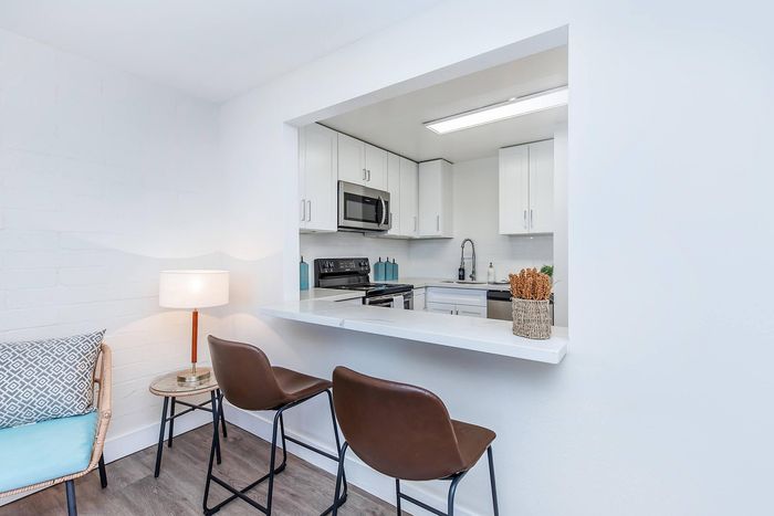 Bright and modern kitchen with sleek appliances, stylish bar seating, and elegant decor, perfect for comfortable living and entertaining.