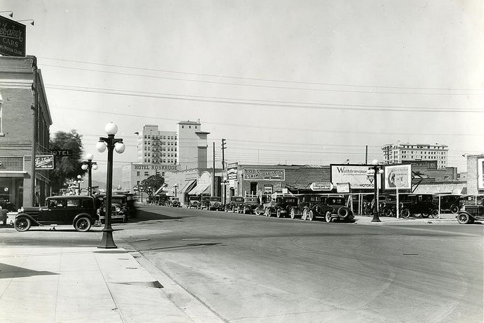Charming 1920s city street scene with vintage cars and classic architecture, capturing the essence of historic urban life.