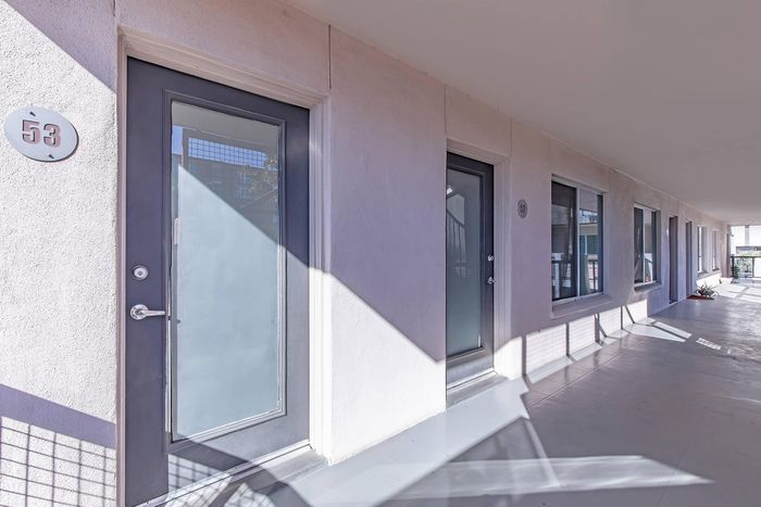 Bright and inviting apartment corridor with sleek modern doors and elegant architecture, enhancing the welcoming atmosphere.