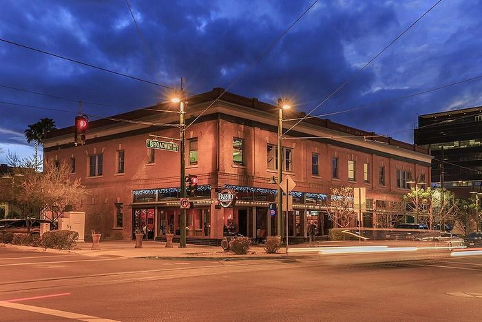 Charming urban street corner at dusk with historic brick architecture and ambient lighting, showcasing a vibrant nightlife scene.