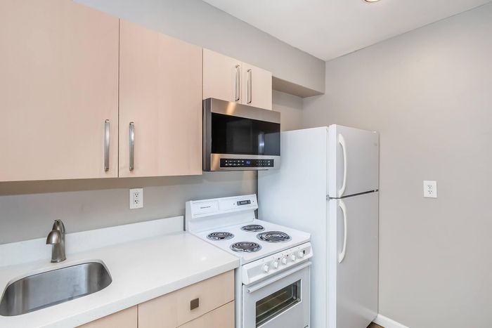 Modern kitchen with sleek cabinetry, stainless steel microwave, and crisp white appliances for a contemporary look.