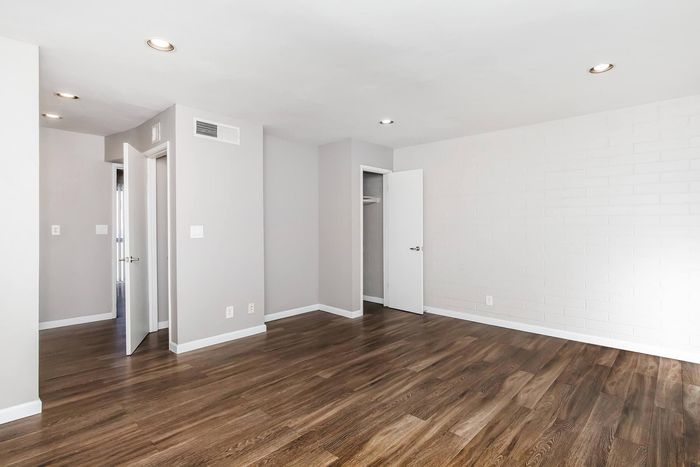 Modern apartment interior featuring sleek hardwood floors, fresh neutral walls, and recessed lighting creating a bright and inviting space.