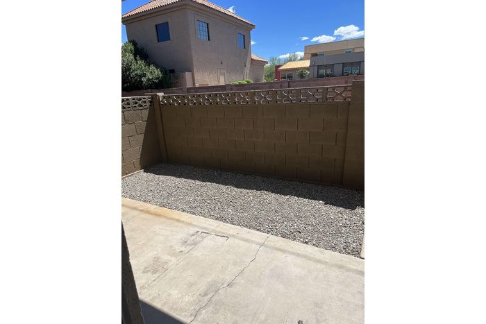 Charming outdoor space with a private walled patio, ideal for relaxing under the blue sky.