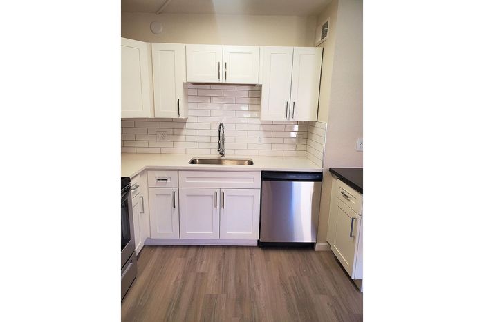Modern kitchen featuring sleek white cabinetry, stainless steel appliances, and elegant subway tile backsplash.