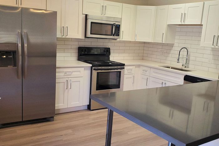 Modern kitchen with sleek stainless steel appliances, stylish white cabinetry, and a spacious countertop perfect for entertaining.