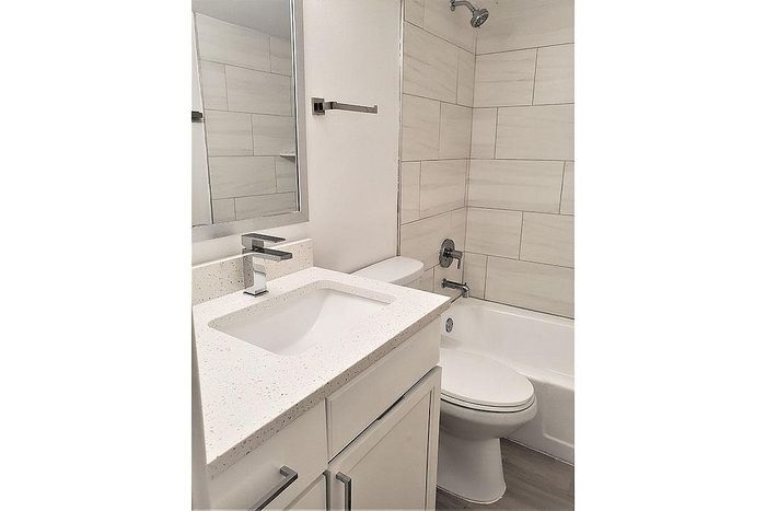 Modern bathroom featuring sleek fixtures, a polished countertop, and elegant tiled walls for a luxurious experience.