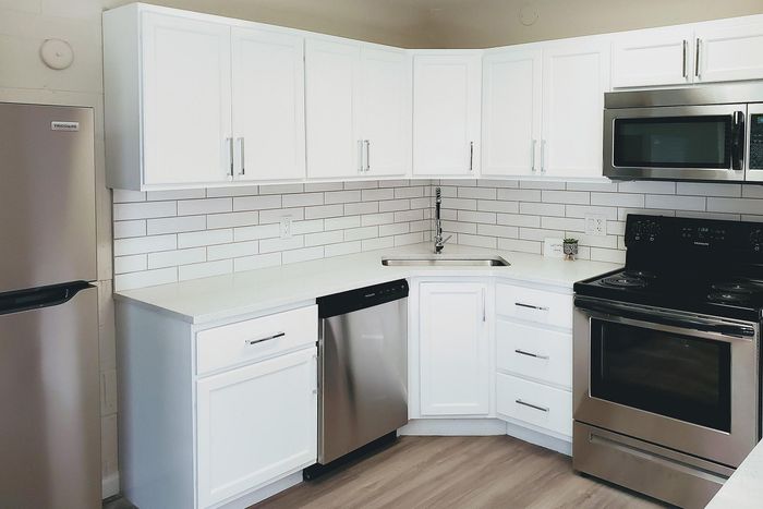 Elegant kitchen with modern stainless steel appliances, sleek white cabinetry, and chic subway tile backsplash.
